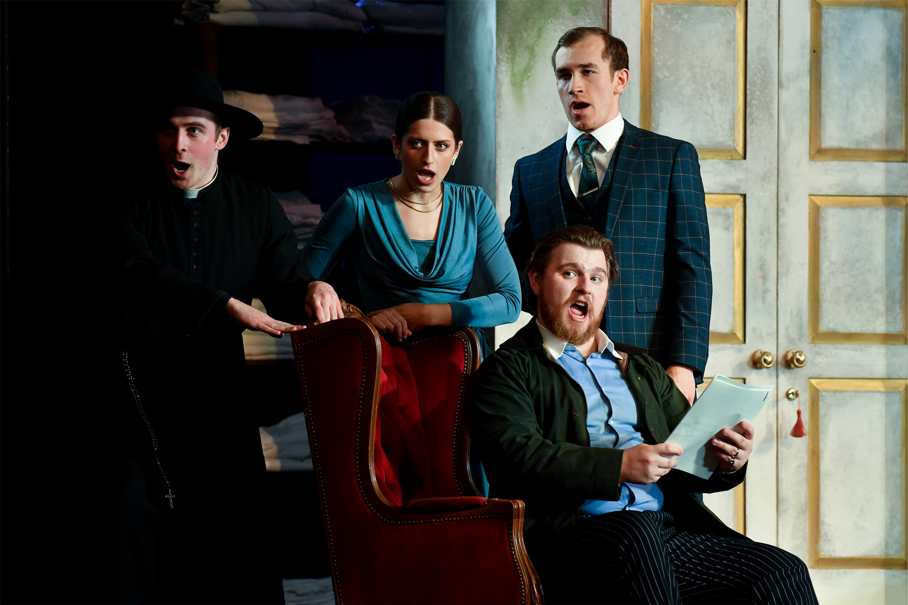 A group of opera students performing on stage in period costume.